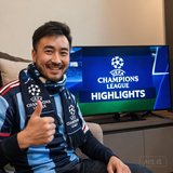 一位戴着围巾的男性球迷，面带微笑表示对欧冠集锦频道的满意